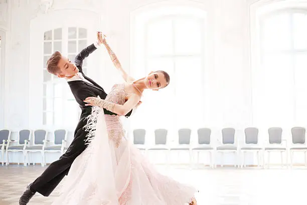 Young couple of professional ballroom dancers in movement