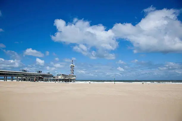 The Pier in Scheveningen, Netherlands with beach and dramatic sky