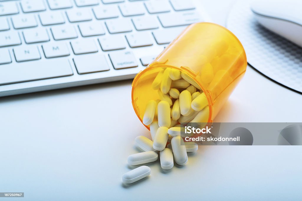 Botella de comprimidos en un ordenador - Foto de stock de Cápsula libre de derechos