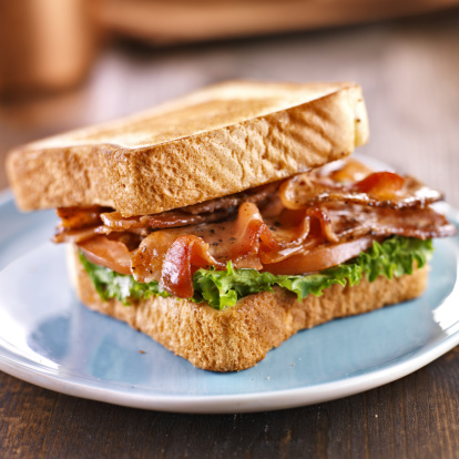 BLT bacon lettuce tomato sandwich with toast off to the side.