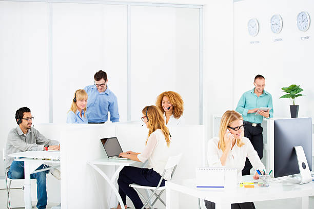 Teamwork at call center. Selective focus to businesswoman working as manager in front of the group.