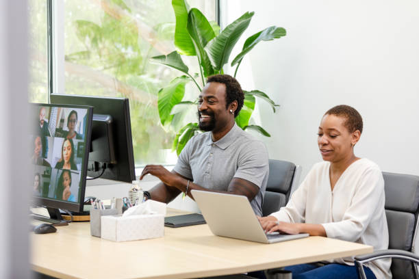 istock Diverse group of employees smile while sitting in the conference room to work on a project together 1872535057