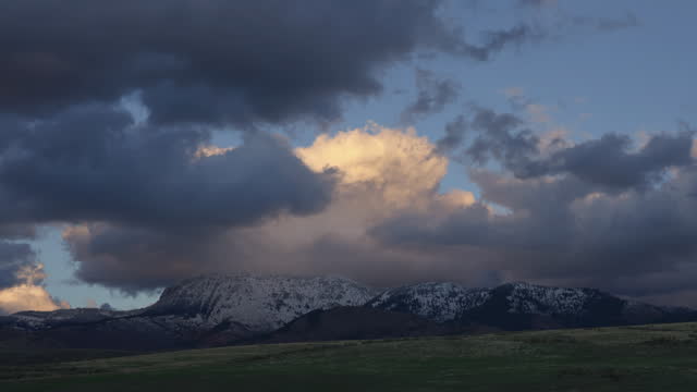 Gloomy Sky With Sunset Clouds Crawling Over Snow Rock Mountains. Timelapse
