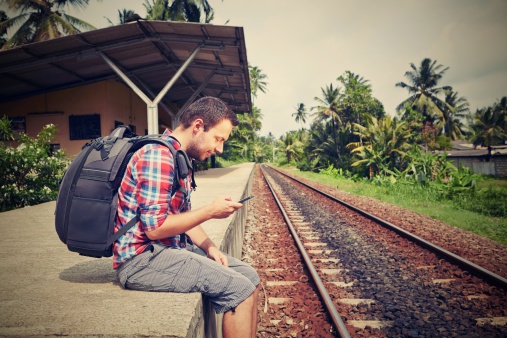 Young traveler with mobil phone in the railway