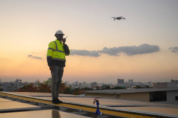 istock Male engineer works installing solar panels on the roof. Engineer or worker working on solar panels or photovoltaic cells on the roof of a business building. 1872553511