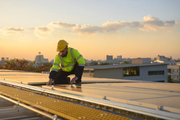 istock Male engineer works installing solar panels on the roof. Engineer or worker working on solar panels or photovoltaic cells on the roof of a business building. 1872555218
