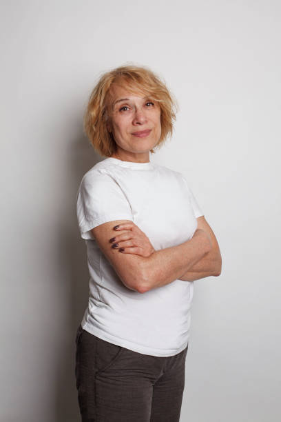 istock Smiling mature woman standing on white background, studio portrait 1872566343