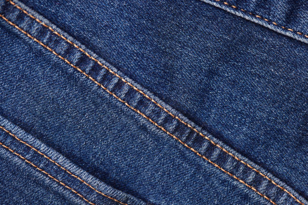 istock Seams on jeans close-up. Stitching on denim. Fabric texture. Blue jeans background and texture. Close up of blue jeans background. Denim texture in high-resolution 1872570709