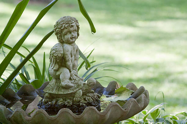 istock Garden angel rides turtle in birdbath 187257325