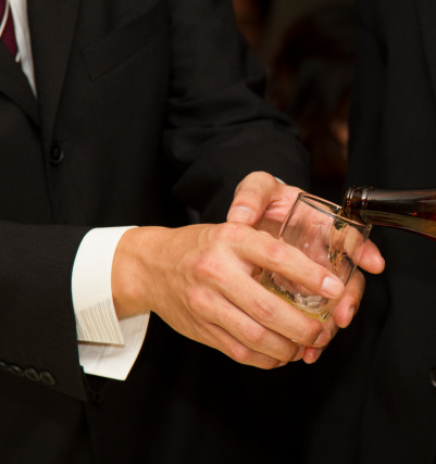 A Japanese businessman politely receiving beer in his glass.