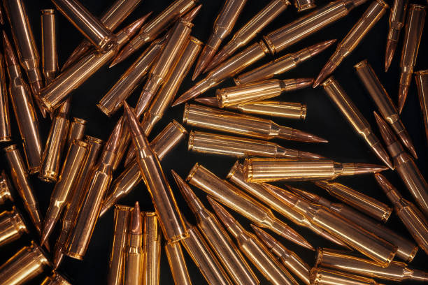 istock Ammonution on dark table. Ammo pile, war ammo background. Rounds and military technology. Guns and Ammo background. Production of ammunition at the factory. Bullet ammunition manufacturing process. 1872613815