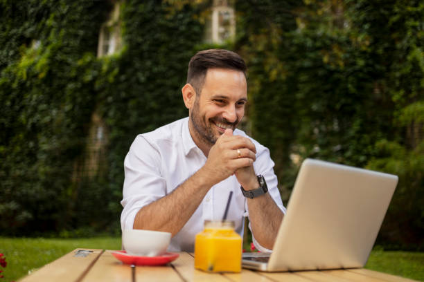 istock Bearded Smart Casual Businessman Using Laptop in Cafeteria 1872620369