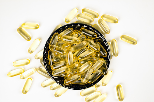 Omega 3 capsules on a black plate. Fish oil capsules. Dietary supplement