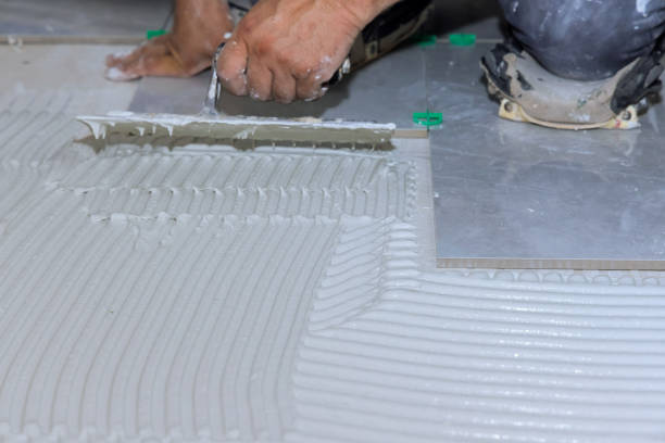 istock Applying adhesive mortar cement plaster surface to floor for lays ceramic tile 1872639585