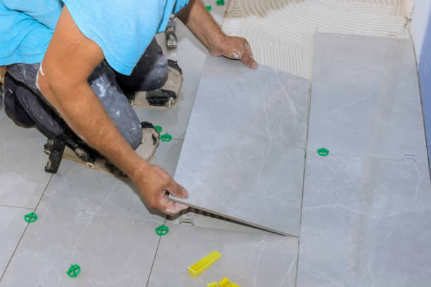 istock Tiler worker lay large tiles on ceramic floor tile over a mortar adhesive 1872639589