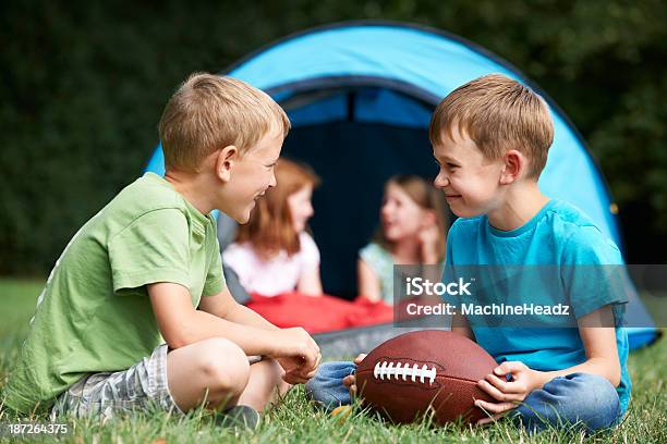 Foto de Dois Meninos Brincando Com Futebol Americano No Acampamento Viagem e mais fotos de stock de Acampar