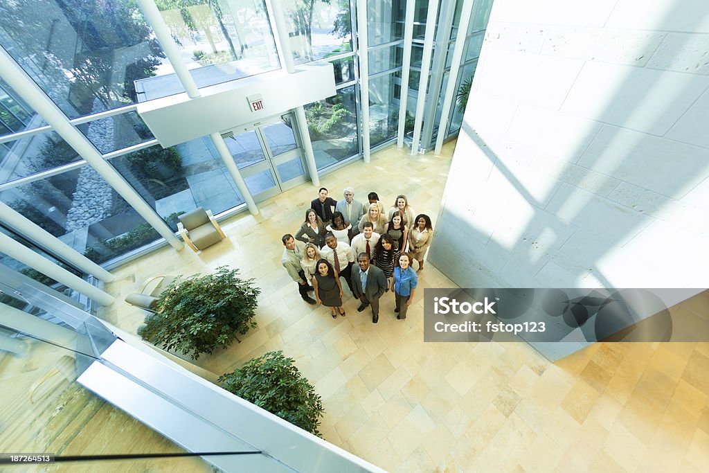Negocios: Grupo multiétnico de los colegas se reúnen en oficina del lobby. - Foto de stock de Atrio - Característica arquitectónica libre de derechos