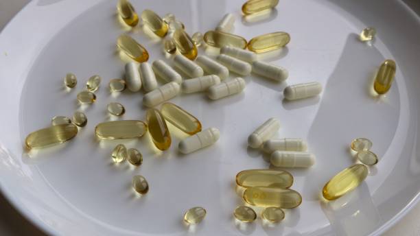 istock different capsules with vitamins or medicines on a white plate 1872673041