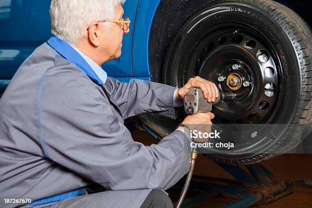 En El Garaje De Reparación De Automóviles Está Cambiando Tire Mecánico Foto de stock y más banco de imágenes de Columpio de rueda de coche