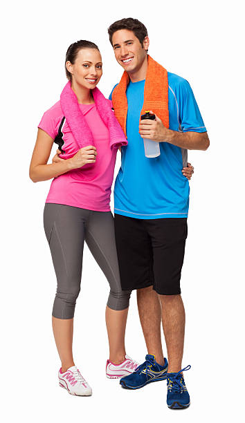 Full length portrait of young couple standing together with towels around their necks after a gym workout. Vertical shot. Isolated on white.
