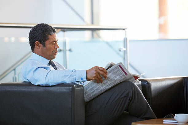 istock Mature businessman reading a newspaper at office lounge 187268096