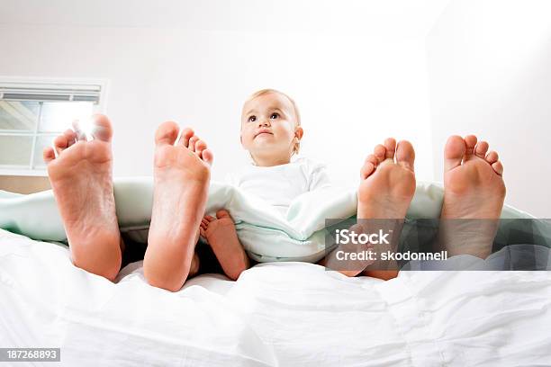 Bebé En La Cama Con Madre Y Padre Foto de stock y más banco de imágenes de Mujeres - Mujeres, 12-23 meses, Acogedor