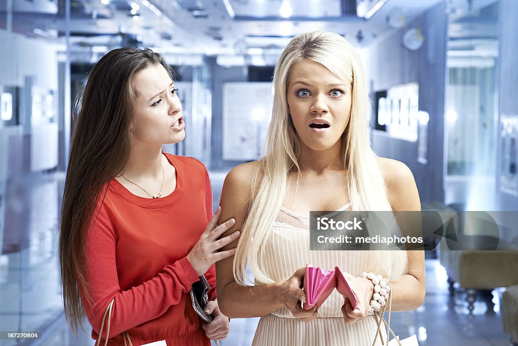 Short of money Shocked girl standing with open change purse and the friend consoling her 20-29 Years Stock Photo