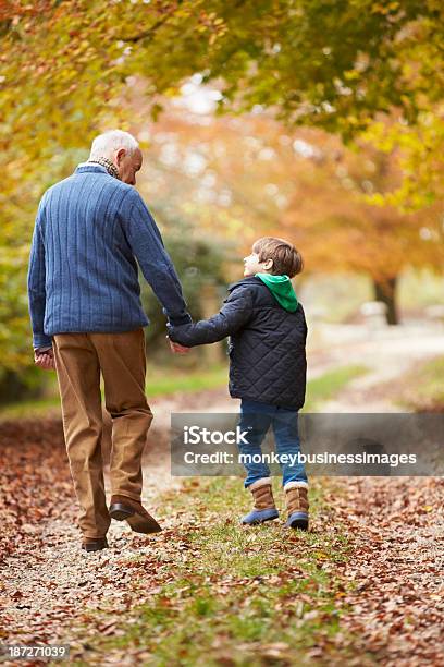 Rear View Of Grandfather And Grandson Walking Along Path Stock Photo - Download Image Now