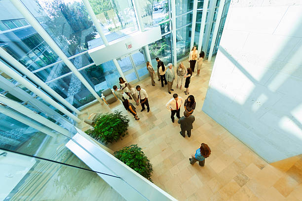 Business: Group of multi-ethnic, co-workers arrive for work. Group of multi-ethnic, business people arrive for work in office lobby. headquarters photos stock pictures, royalty-free photos & images