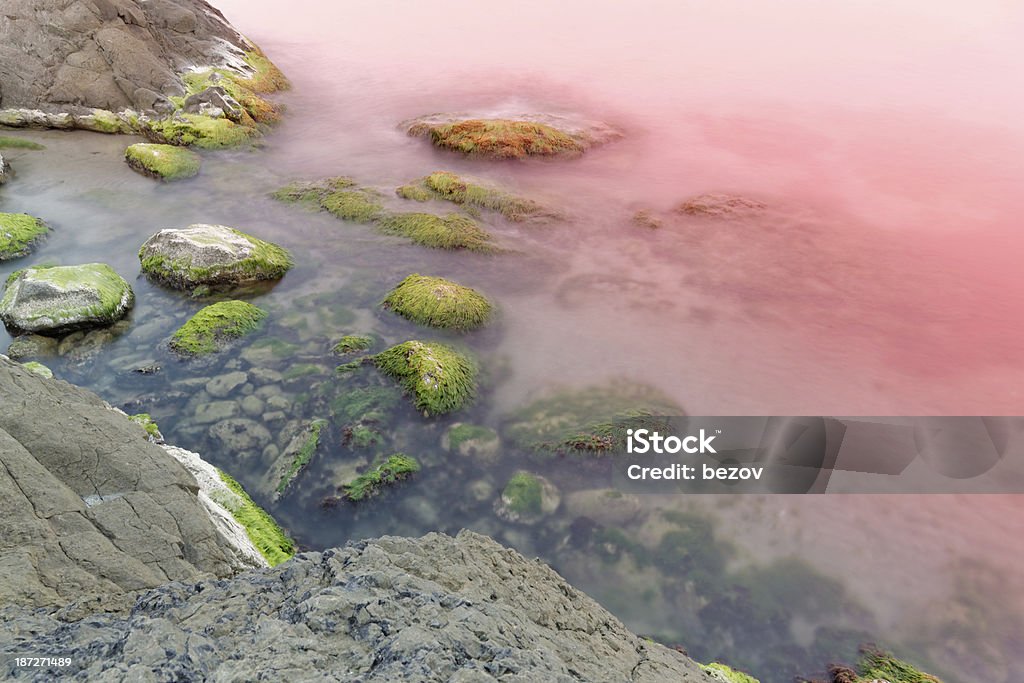 Pôr do sol sobre rocky beach - Foto de stock de Mar royalty-free