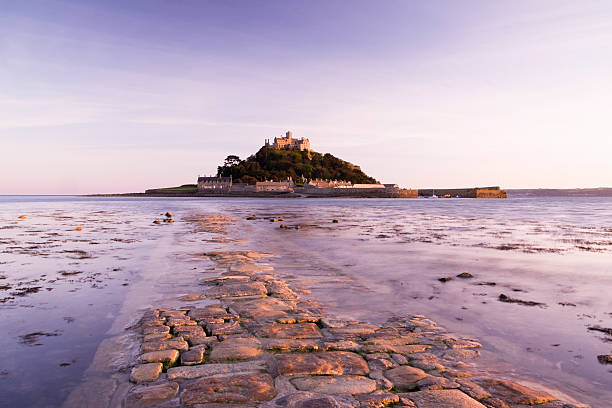 A small rocky island with a medieval village and church – the oldest buildings dating from the 12th century. Situated in mounts bay, just off the coast from Marizion and near penzance, Cornwall, England. Slight motion blur on the waters surface.