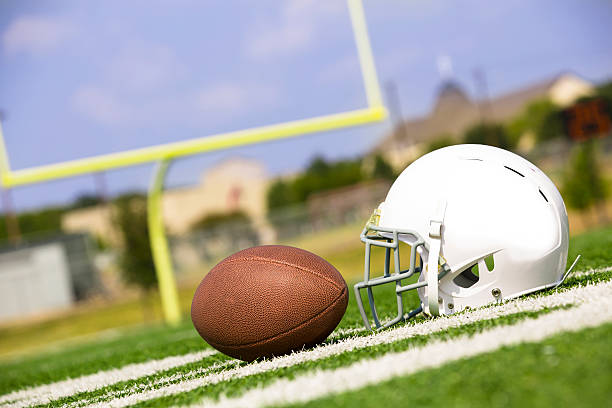 istock Sports:  Football and helmet on playing field. 187272757