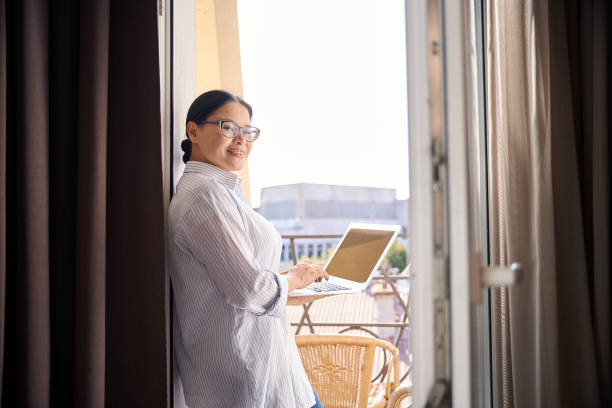 istock Smiling female freelancer is working on portable computer in morning 1872730303