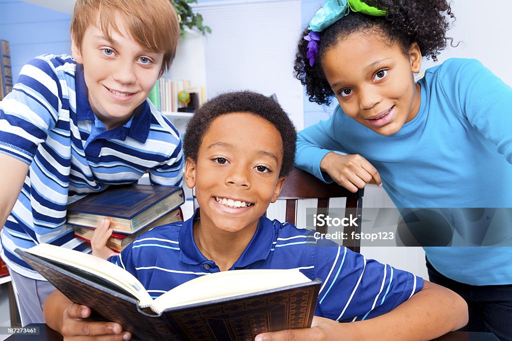 Educação: Multi-étnico de jovens alunos na biblioteca.  Lendo livro, estudar. - Foto de stock de Criança royalty-free