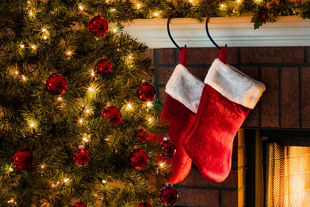 istock Christmas tree, and stockings hanging from mantel by fireplace 187274749
