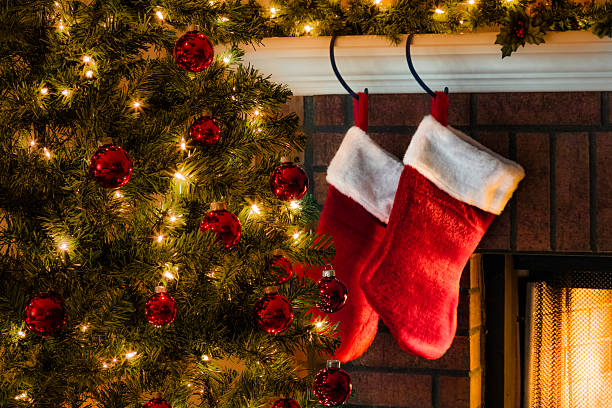 Christmas tree, and stockings hanging from mantel by fireplace Christmas tree, and stockings hanging from mantle by fireplace.Waiting for SantaChristmas tree, and stockings hanging from mantle by fireplace christmas stocking stock pictures, royalty-free photos & images