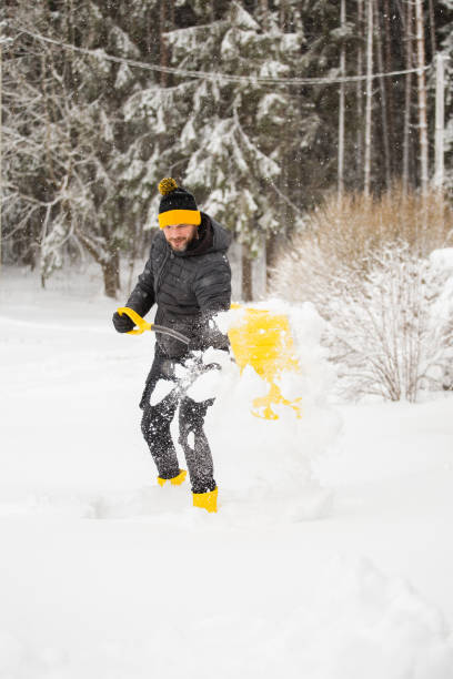 istock A man with a shovel throws snow away from the house 1872747778
