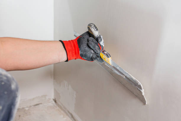 istock Leveling the wall surface with white putty and a spatula 1872747953
