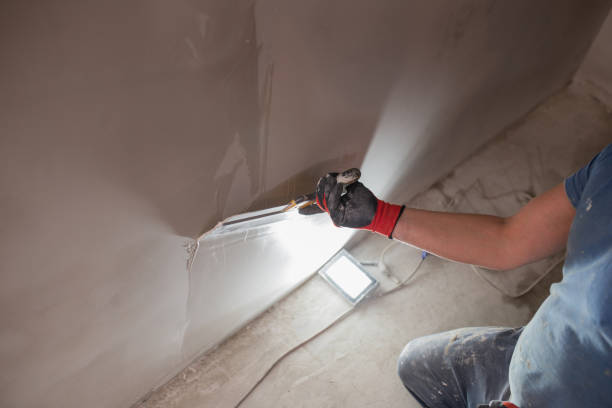istock Leveling the wall surface with white putty and a spatula 1872747961