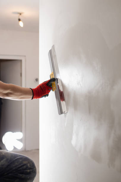 istock Leveling the wall surface with white putty and a spatula 1872748288