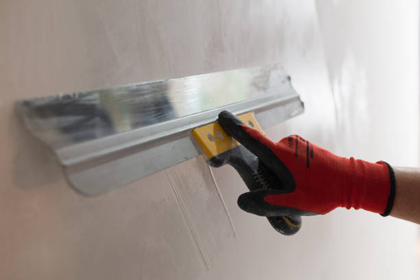 istock Leveling the wall surface with white putty and a spatula 1872748301