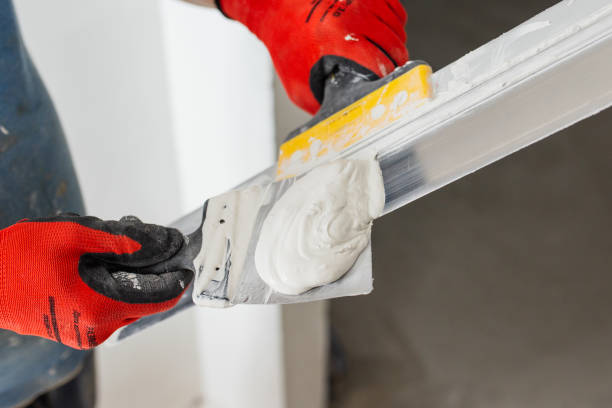istock Leveling the wall surface with white putty and a spatula 1872748313
