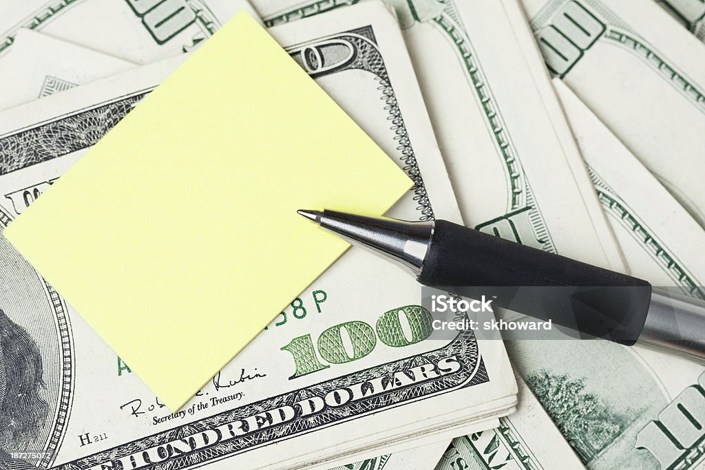 Money Pen and adhesive note on top of a stack of US one hundred dollar bills. Abundance Stock Photo