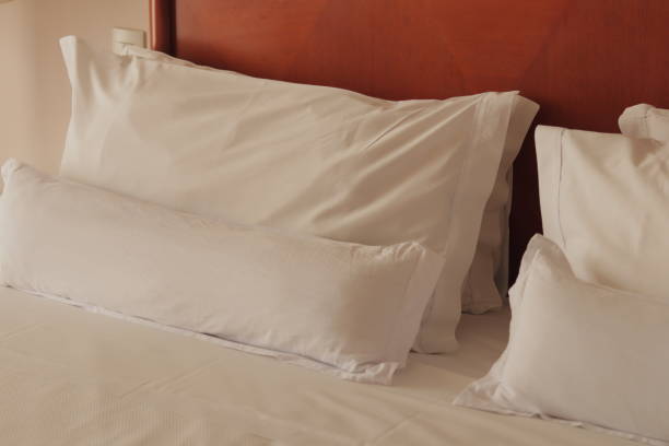 istock Bed with Wooden Headboard and White Bedding and Pillows with Pillowcases 1872755619