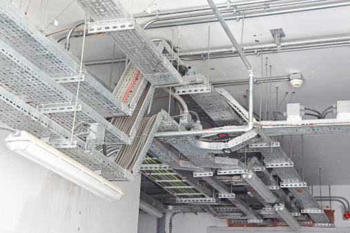 An architectural detail from a technical service building demonstrating handling of cables via cable trays (aka overhead cable management racks).