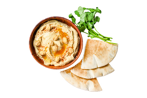 Hummus paste with pita bread, chickpea and parsley in a wooden bowl.  Isolated on white background, top view