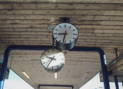 Low angle view of two clocks showing different time