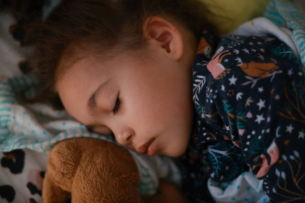 istock Little preschool girl sleeping in comfortable bed 1872812535