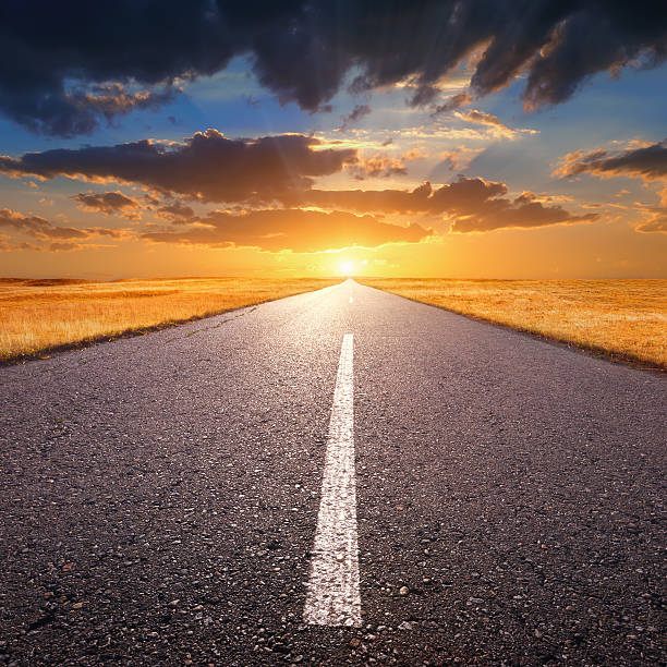 istock Driving on an empty road towards the setting sun 187282298