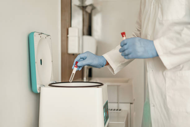 zbliżenie dłoni naukowca w rękawiczkach wkładającego małą plastikową probówkę do mikrowirówki - laboratory blood laboratory equipment medical sample zdjęcia i obrazy z banku zdjęć